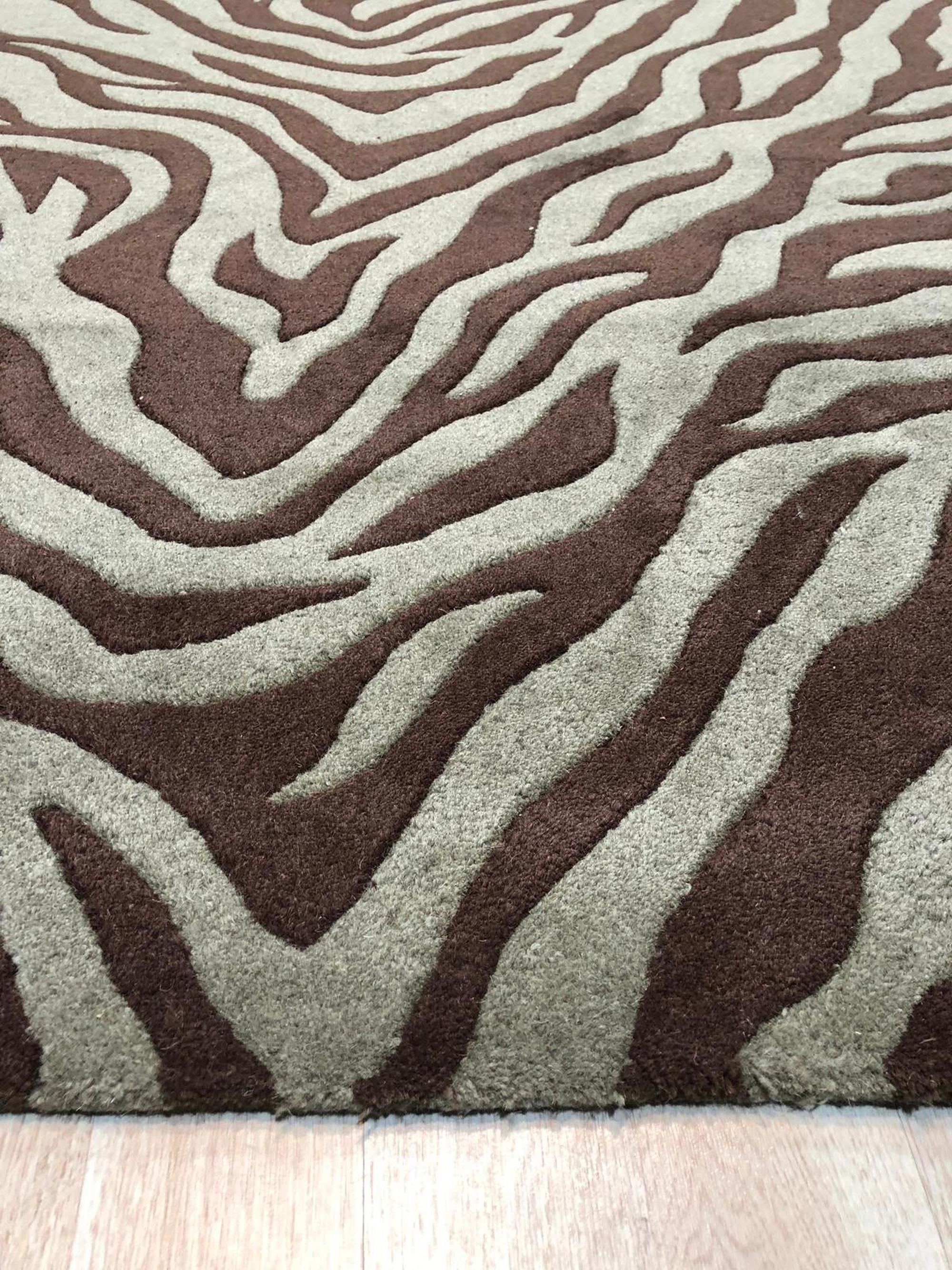 Giselle Xena Green Hand Tufted Wool Rug, soft green tones and textured pile visible, laying flat in a brightly lit room showcasing its construction and subtle pattern.