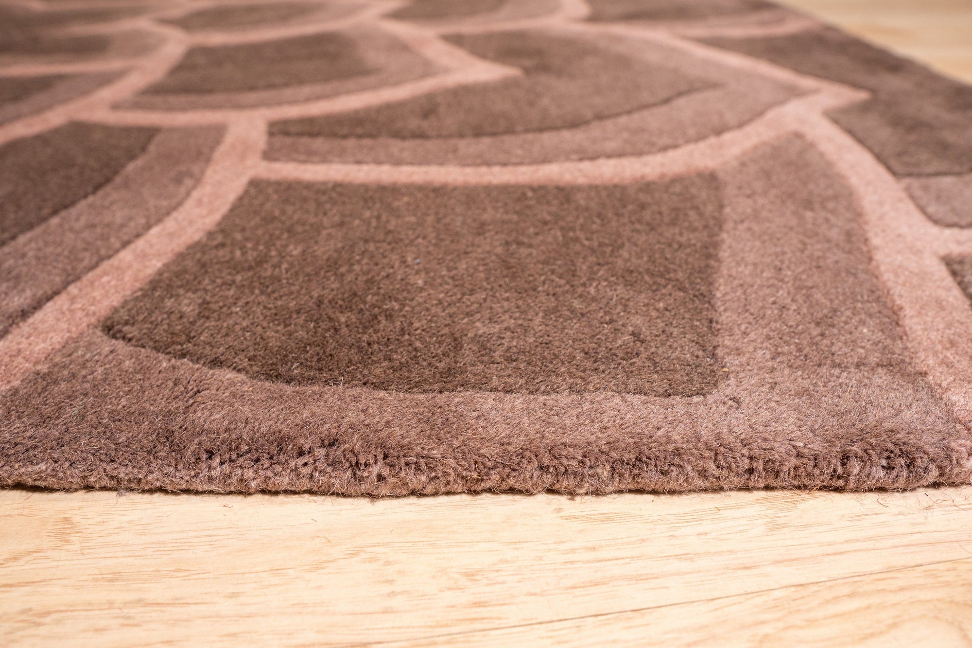 Versatile Kira Brown Hand Tufted Wool Rug displayed in a modern living room setting; warm brown tones and hand-tufted texture complement the neutral decor.