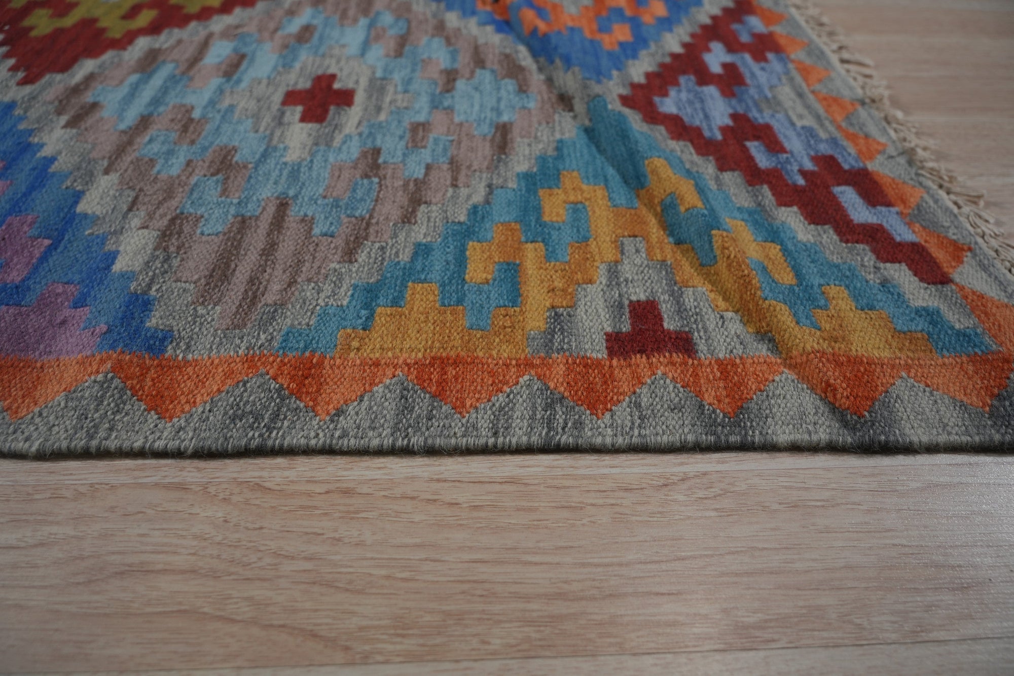 Iris Sophisticated Multicolor Flatweave Wool Rug, a vibrant array of hues woven into a flatweave construction, adds warmth and contemporary style to a modern living room setting.