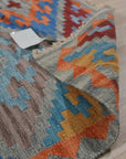 Iris Sophisticated Multicolor Flatweave Wool Rug, showcasing its vibrant palette and intricate flatweave construction in a modern living space. Warm sunlight highlights the rug's textural details and rich color variations.
