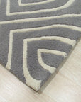 Beautiful Luna Gray Hand Tufted Wool Rug, showcasing its soft gray hues and hand-tufted texture, laying flat on a light surface suggesting a cozy and inviting atmosphere.