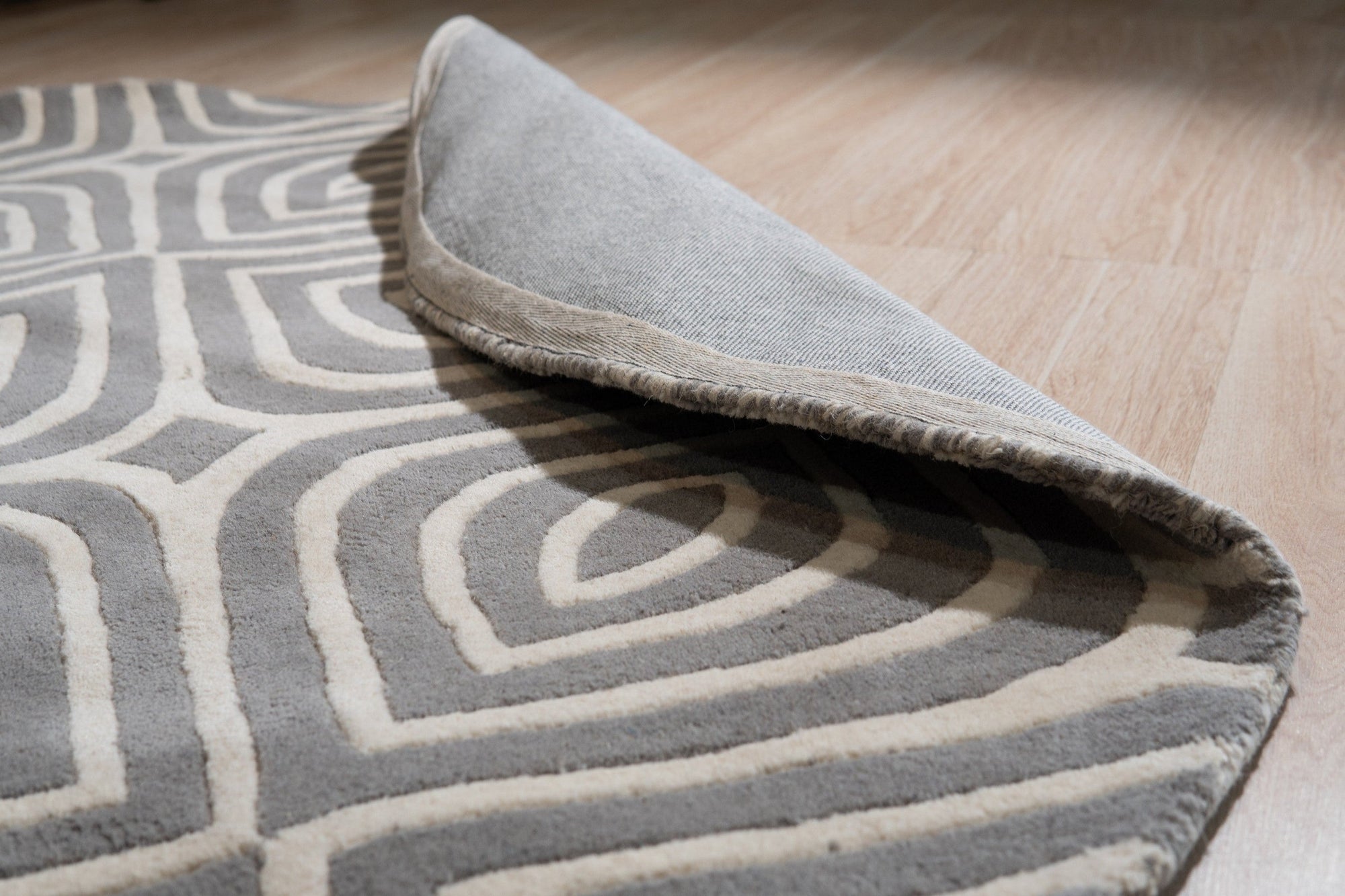 Beautiful Luna Gray Hand Tufted Wool Rug, its plush gray wool surface reflecting soft light in a bright, modern living room.