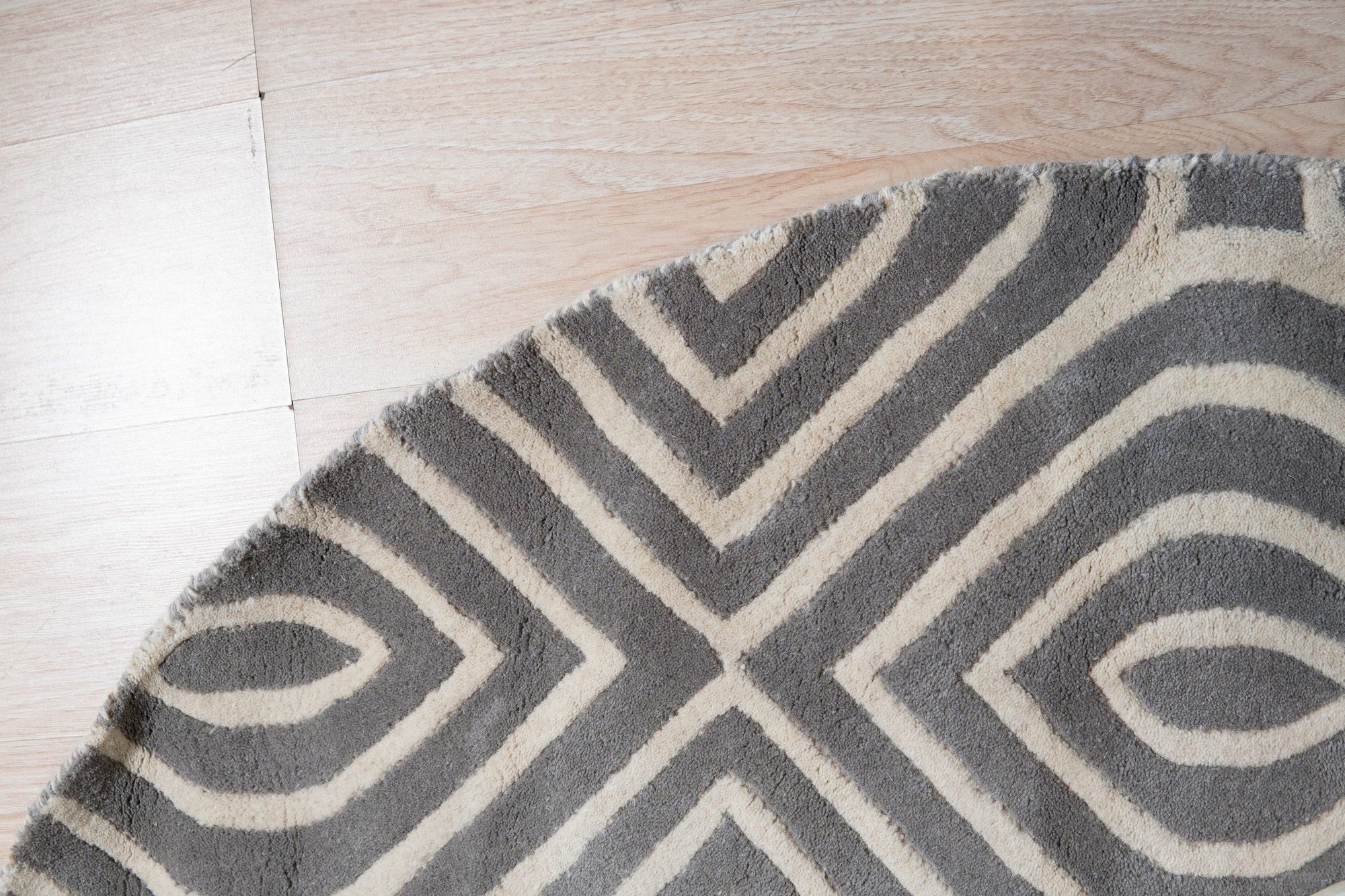 Beautiful Luna Gray Hand Tufted Wool Rug, its soft gray tones and plush wool texture inviting touch and warmth, lies elegantly on a light wood floor.