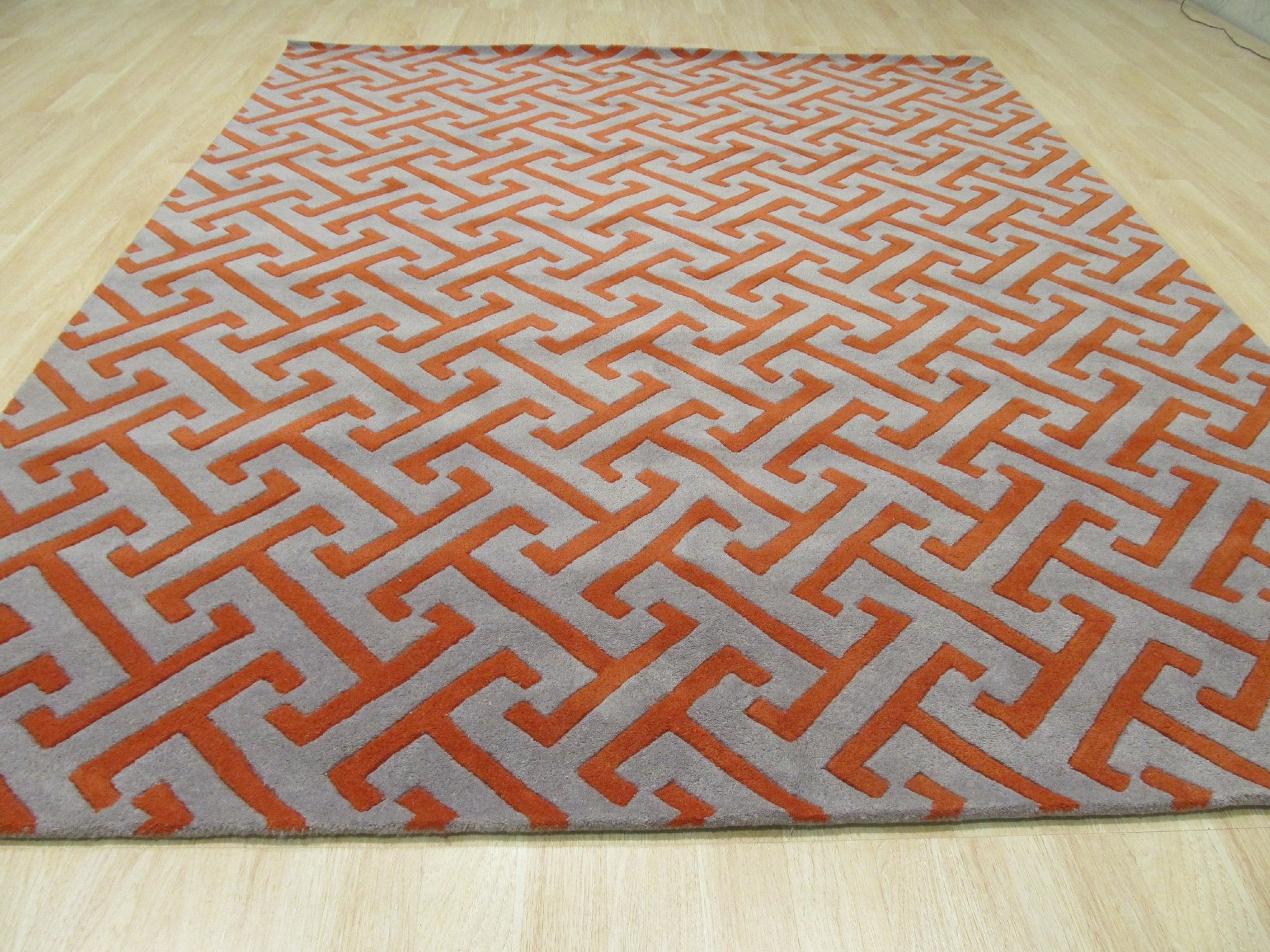 Comfortable Celia Gray Hand Tufted Wool Rug, showcasing a soft, textured gray surface suggesting comfort and warmth. Hand tufted construction is evident in the subtle variations of the wool pile, creating a visually appealing and inviting floor covering.