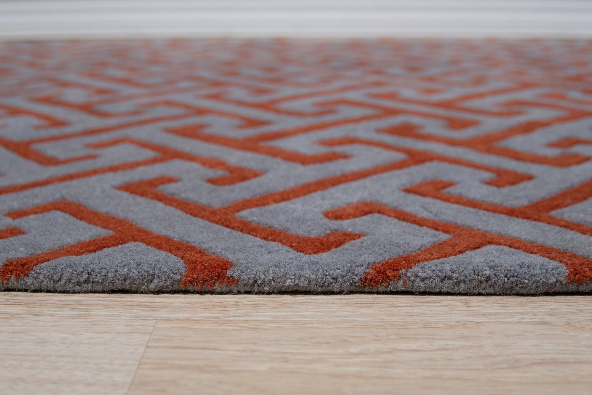 Comfortable Celia Gray Hand Tufted Wool Rug, its soft gray hues and hand-tufted texture adding warmth to a bright, modern living room with light hardwood floors and neutral furniture.