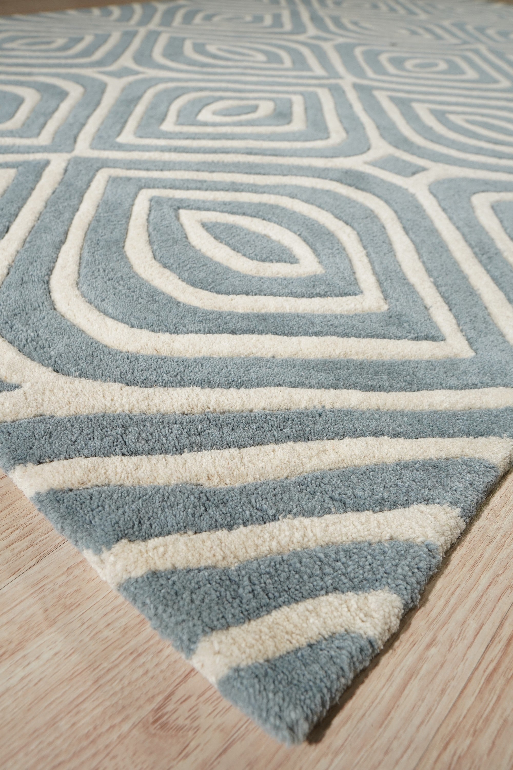 Rhea Stylish Blue Hand Tufted Wool Rug, a calming azure expanse woven with intricate detail, hand-tufted wool creating a soft, inviting texture.