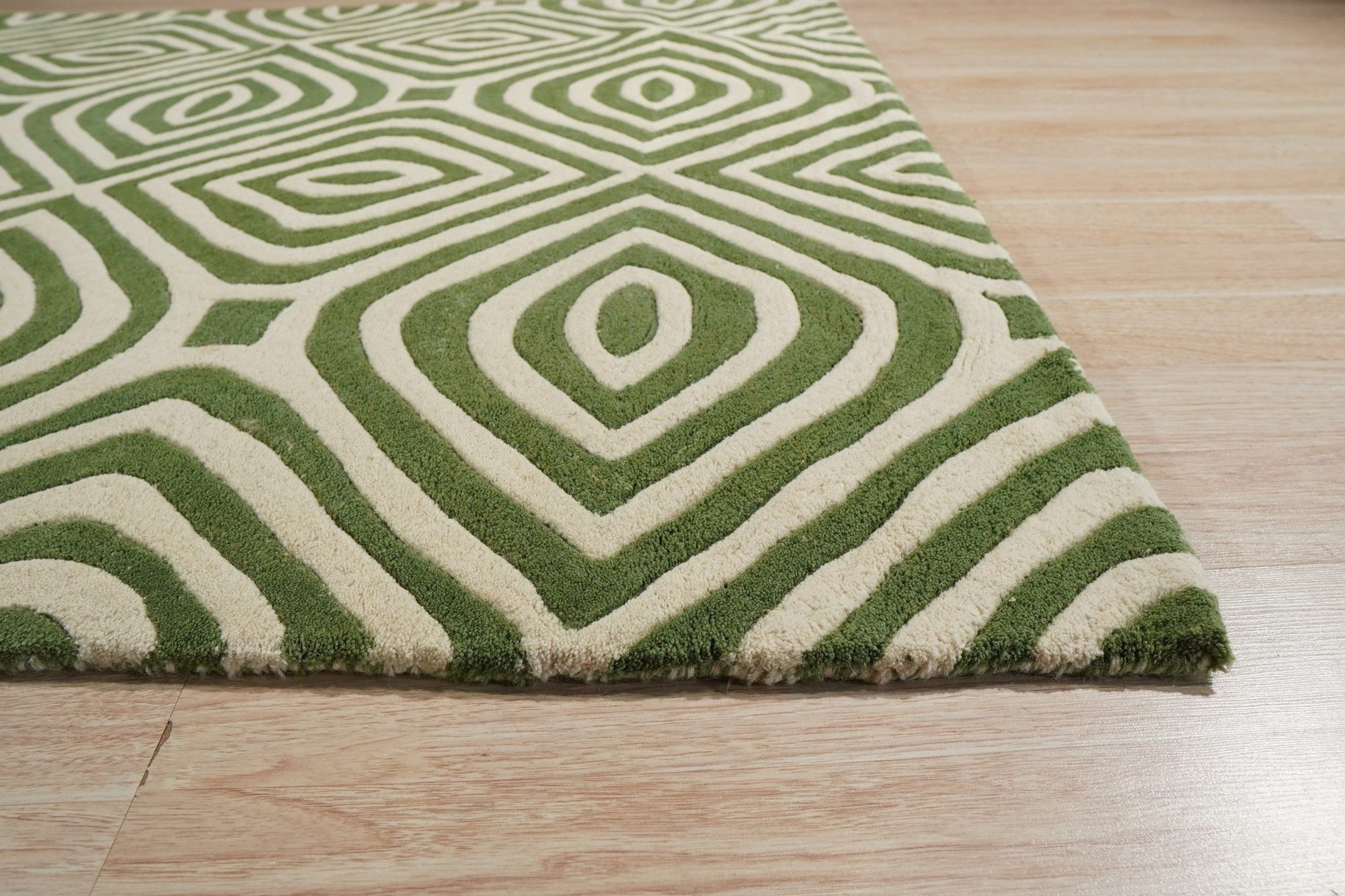 Zinnia Amara Green Hand Tufted Wool Rug, its vibrant green hues and textural weave bring life to a sunlit living room with mid-century modern furniture.