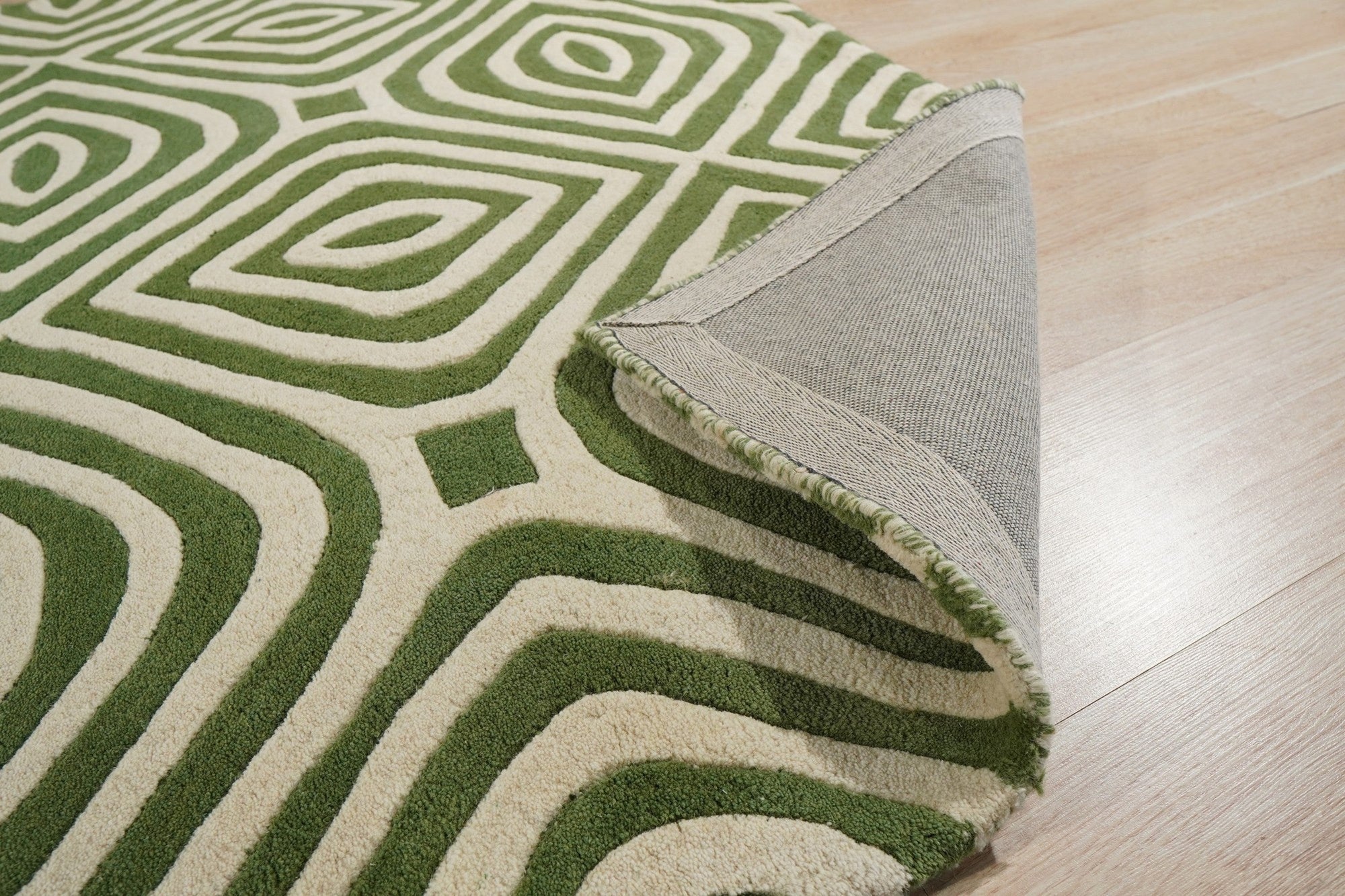 Zinnia Amara Green Hand Tufted Wool Rug, a vibrant splash of verdant green, anchors a contemporary living space. Textured wool pile invites touch, while abstract floral motifs dance across the rug's surface.