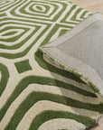Zinnia Amara Green Hand Tufted Wool Rug, a vibrant splash of verdant green, anchors a contemporary living space. Textured wool pile invites touch, while abstract floral motifs dance across the rug's surface.