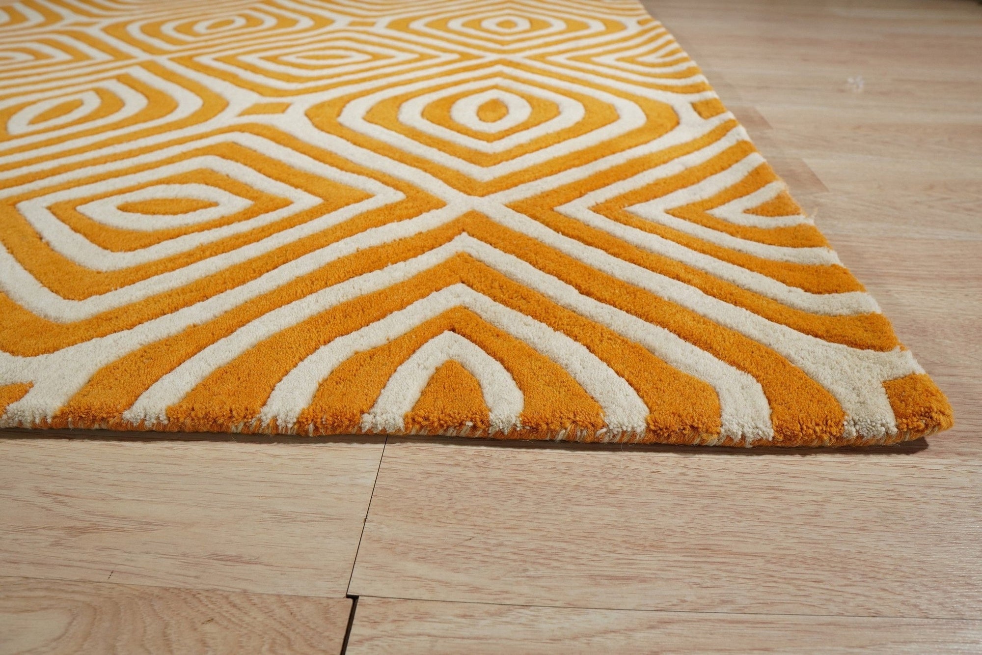 Sophisticated Jade Light Orange Hand Tufted Wool Rug displayed in a warmly lit room; hand tufted construction highlights the intricate pattern blending jade and light orange hues.