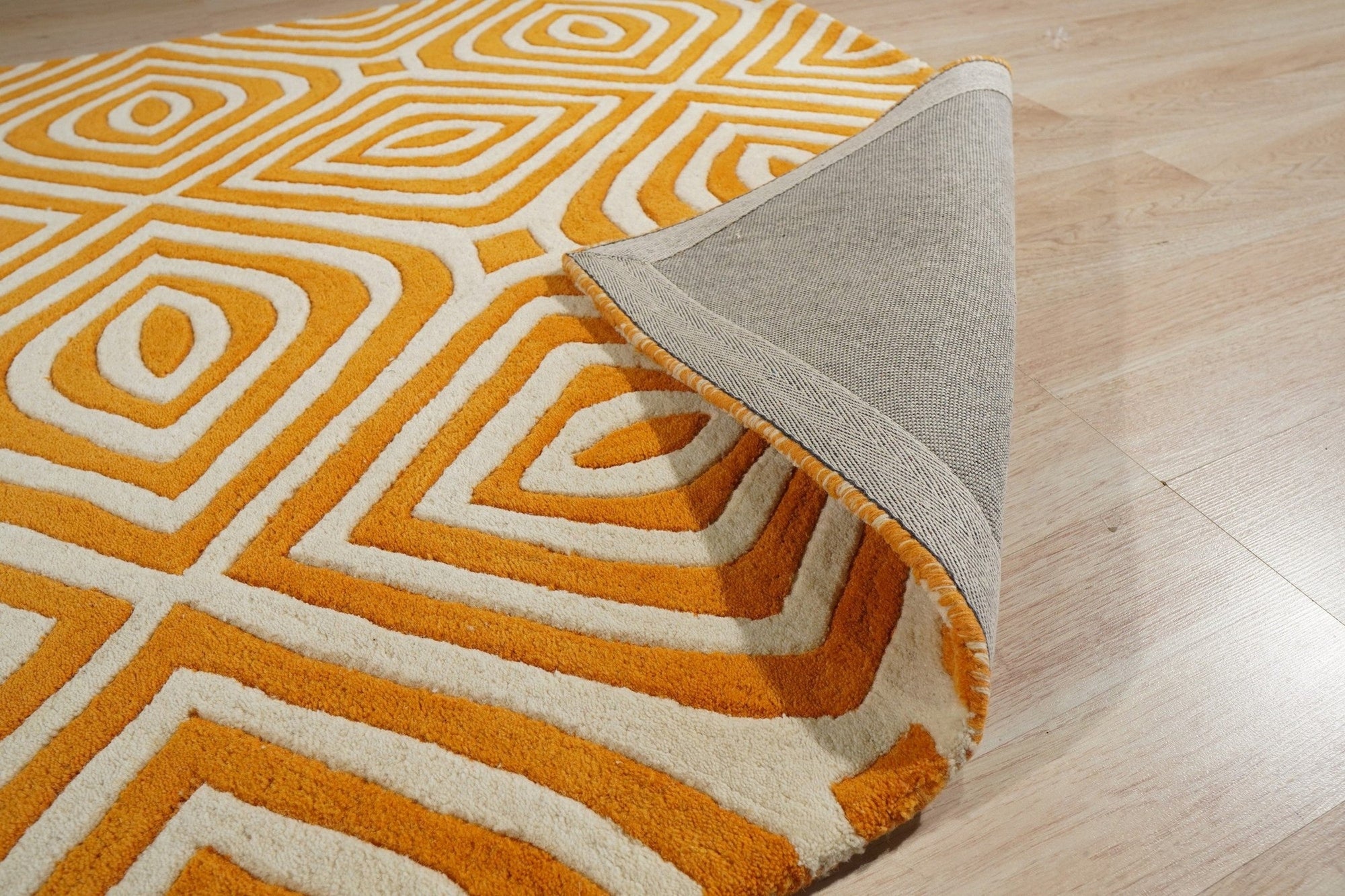 Sophisticated Jade Light Orange Hand Tufted Wool Rug, a calming blend of jade and light orange hues, lying flat on a hardwood floor, its hand-tufted texture visible in the soft lighting.