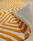 Sophisticated Jade Light Orange Hand Tufted Wool Rug, a calming blend of jade and light orange hues, lying flat on a hardwood floor, its hand-tufted texture visible in the soft lighting.