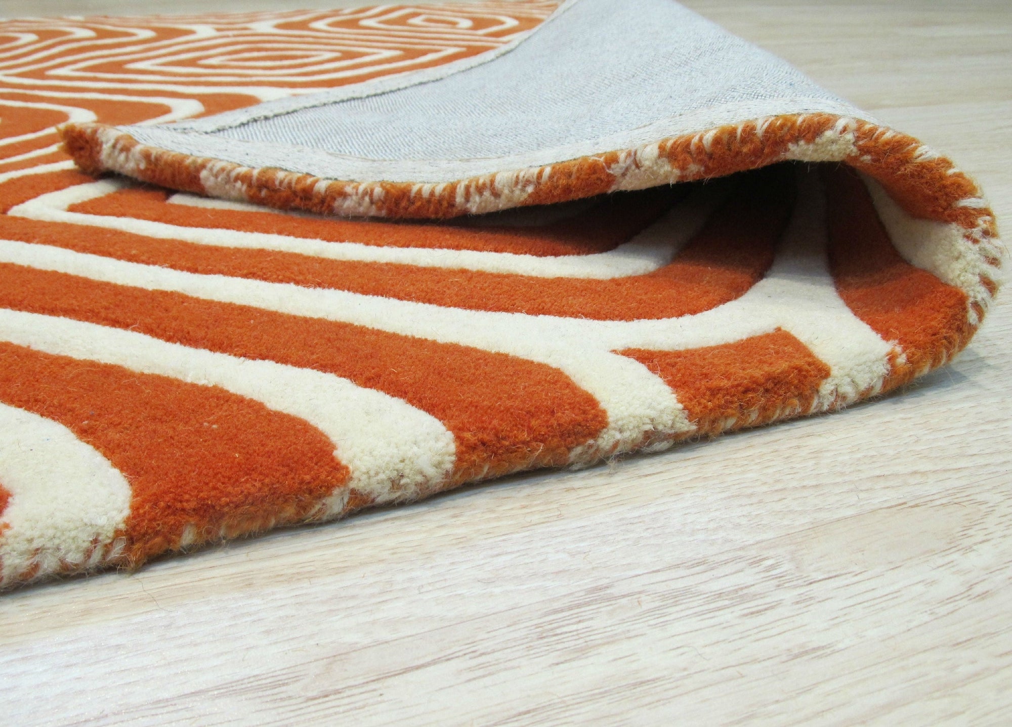 Luxurious Warm Orange Hand Tufted Wool Rug, seen in a warmly lit room, its plush texture and vibrant orange hues creating a cozy and inviting atmosphere.
