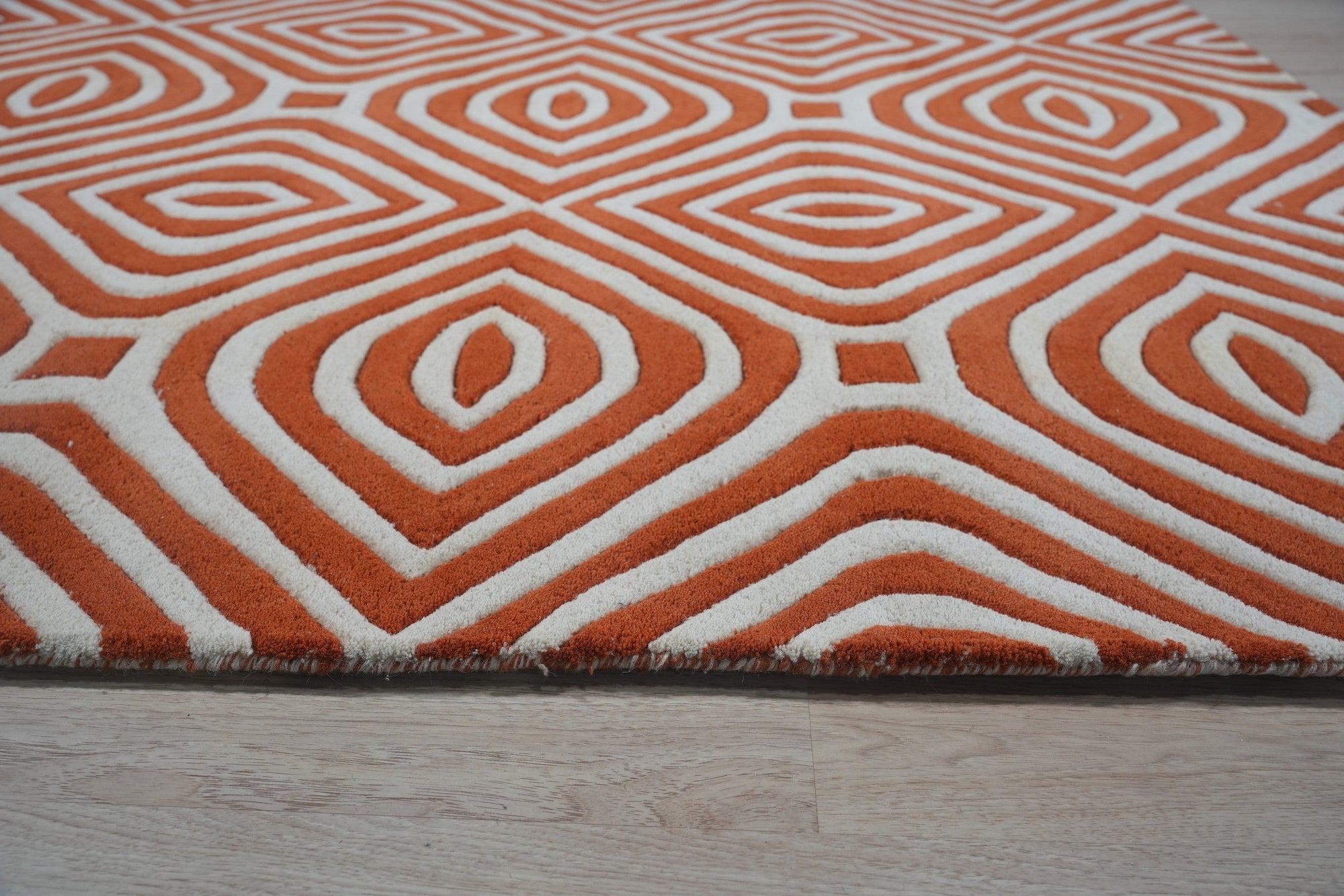 Luxurious Warm Orange Hand Tufted Wool Rug, its vibrant orange hues and plush wool texture adding warmth to a softly lit room.