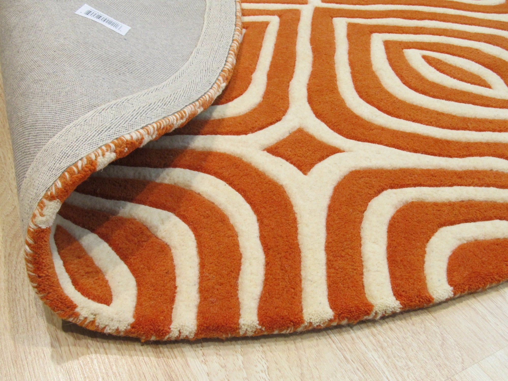 Luxurious Warm Orange Hand Tufted Wool Rug, its plush pile casting a warm glow on a hardwood floor, showcasing the intricate hand-tufted construction and vibrant orange hue.