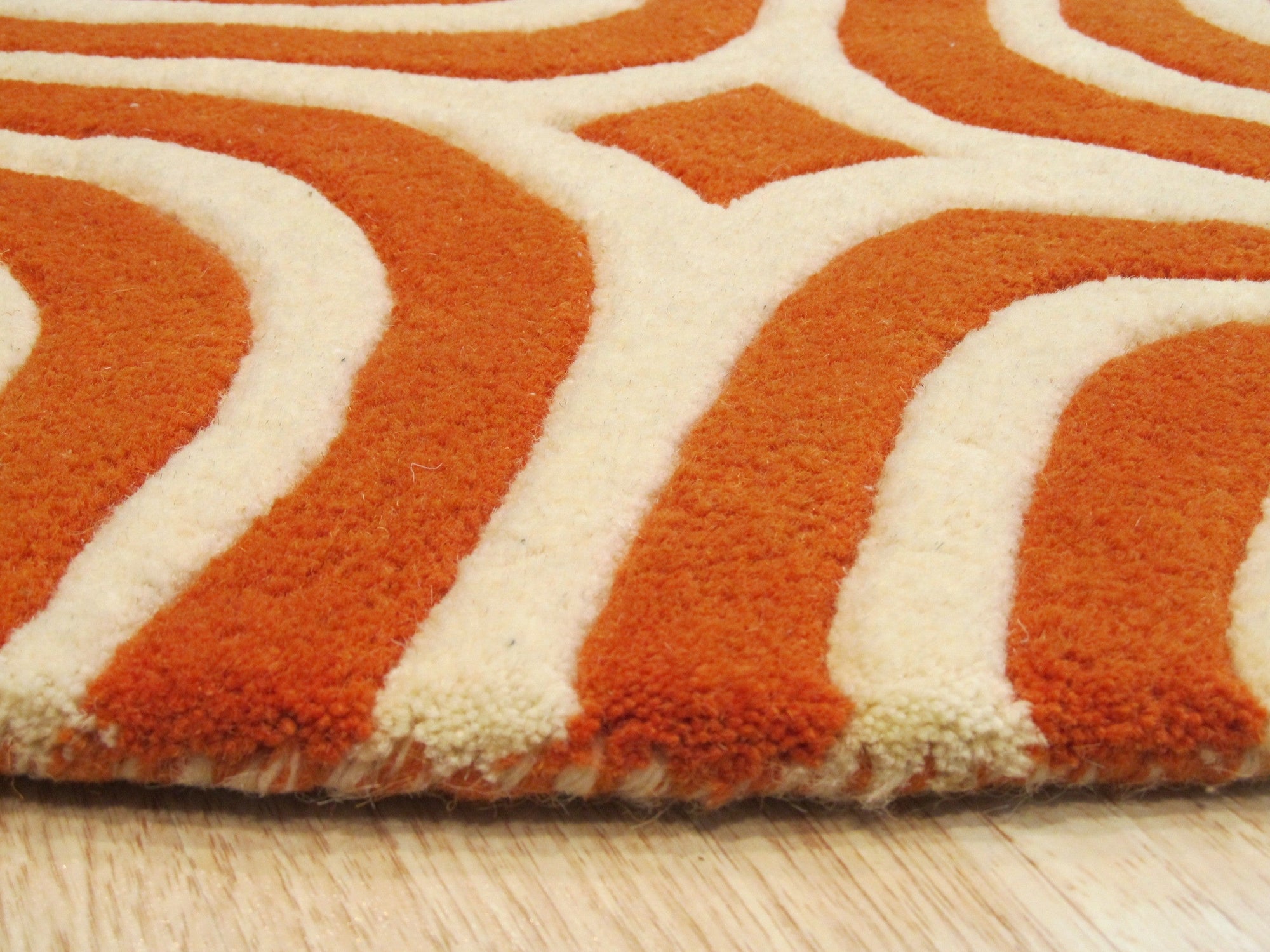 Luxurious Warm Orange Hand Tufted Wool Rug, its plush, hand-tufted wool fibers radiating a rich, warm orange hue, displayed against a neutral backdrop highlighting its texture and color depth.