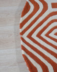 Luxurious Warm Orange Hand Tufted Wool Rug, hand-tufted in a vibrant orange hue, offers plush texture and warmth, shown in a detailed close-up revealing its construction.