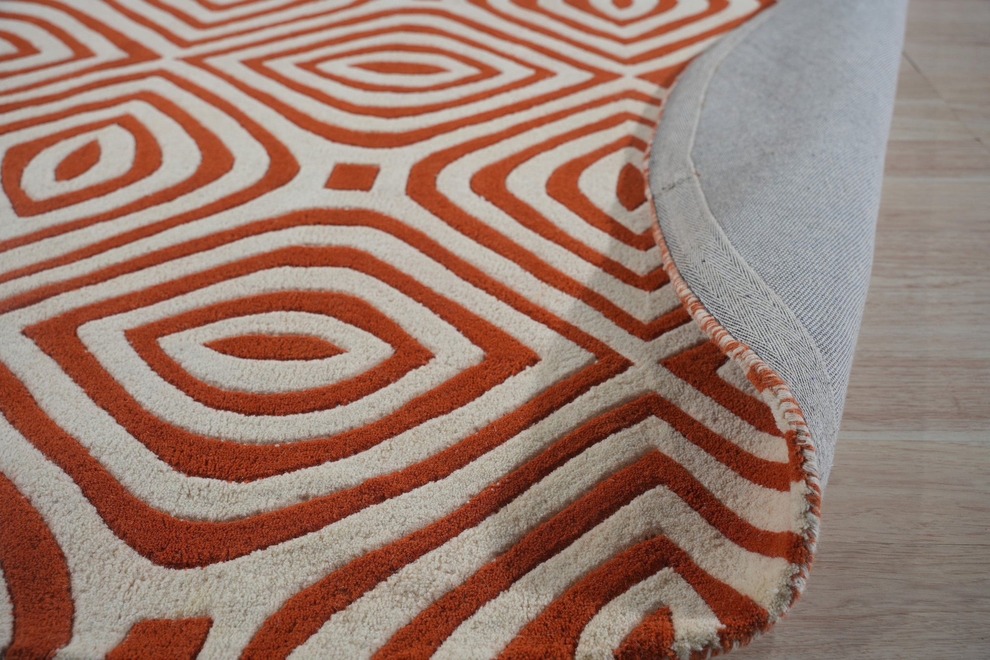 Luxurious Warm Orange Hand Tufted Wool Rug, its plush orange pile radiating warmth in a bright, airy living space.