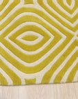 Ruby Para Yellow Hand Tufted Wool Rug, a vibrant geometric pattern in shades of ruby, yellow, and cream, graces a brightly lit living space, adding warmth and texture to the contemporary interior.