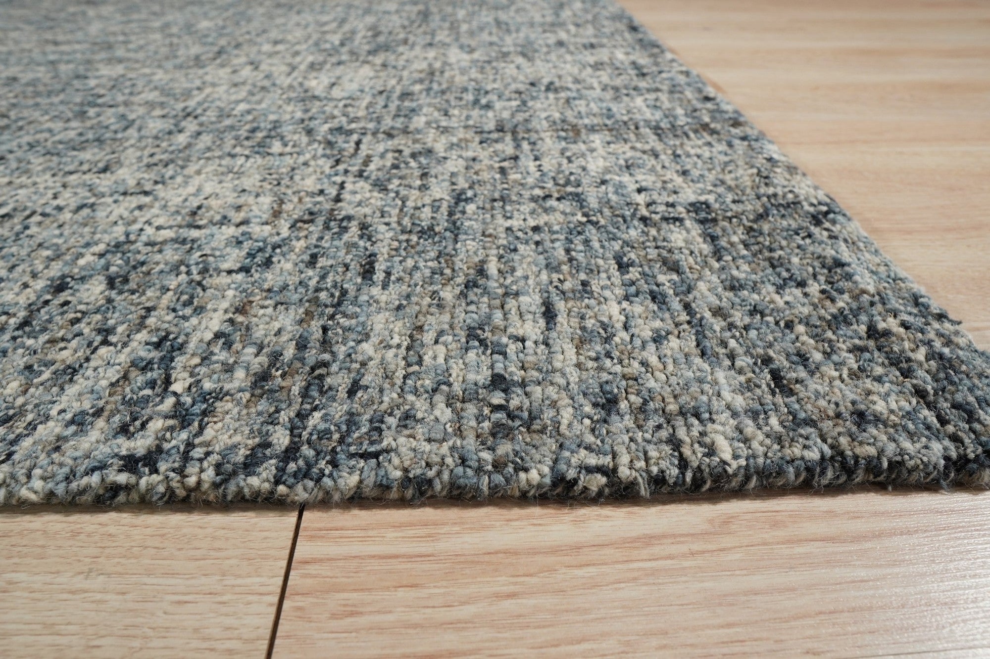 Elena Modern Dark Blue Hand Tufted Wool Rug, showcasing its rich dark blue hues and hand-tufted wool construction within a living room setting.