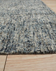 Elena Modern Dark Blue Hand Tufted Wool Rug, showcasing its rich dark blue hues and hand-tufted wool construction within a living room setting.