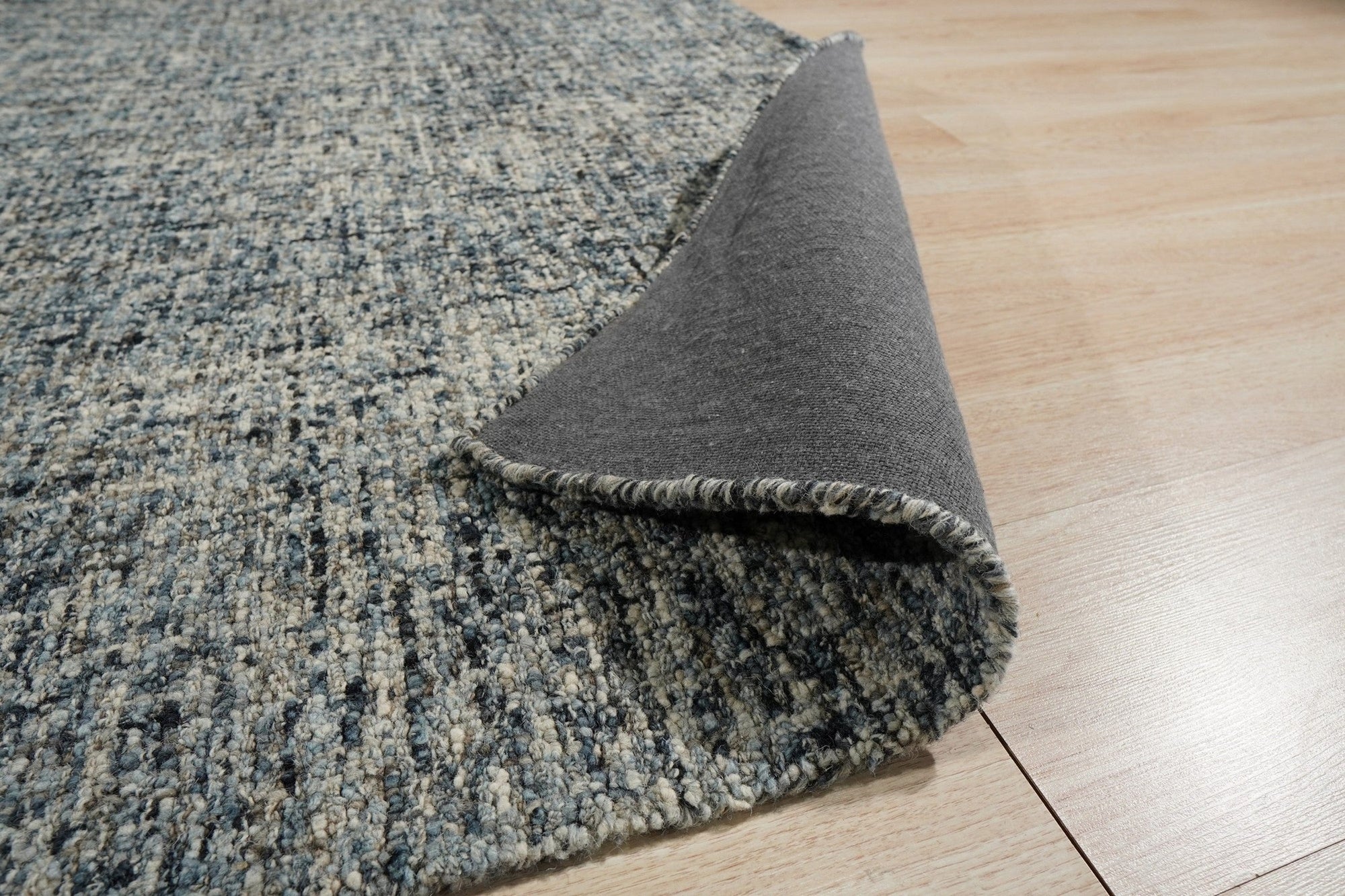 Elena Modern Dark Blue Hand Tufted Wool Rug, a rich indigo and cream wool rug with a subtly textured, modern design, resting in a brightly lit living room setting.