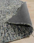 Elena Modern Dark Blue Hand Tufted Wool Rug, a rich indigo and cream wool rug with a subtly textured, modern design, resting in a brightly lit living room setting.