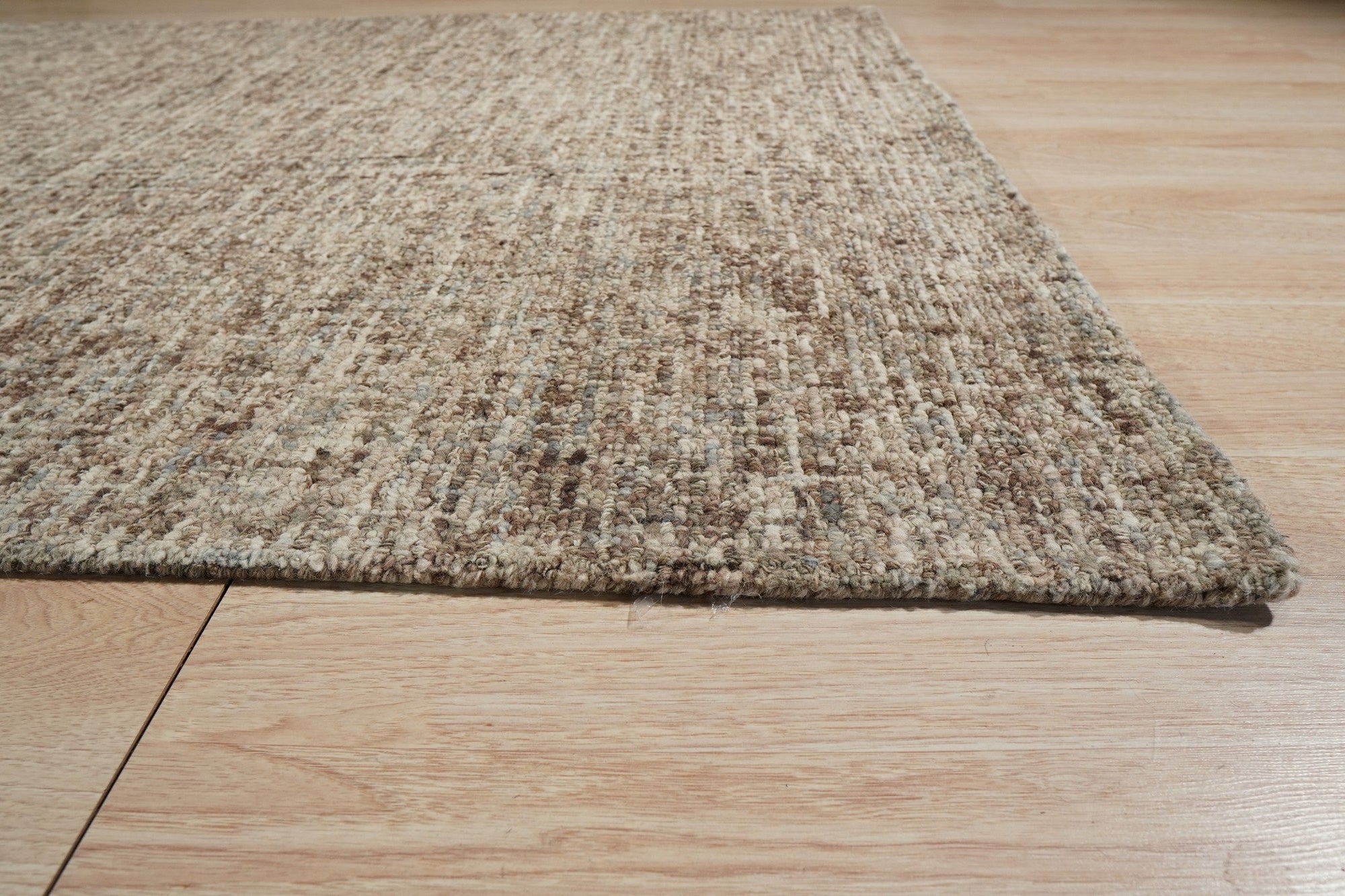 Kira Selene Dark Brown Hand Tufted Wool Rug graces a warmly lit living space, its deep brown tones anchoring a modern setting.