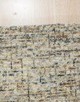 Kira Selene Dark Brown Hand Tufted Wool Rug, its deep brown tones and plush texture grounding a modern living room with a cream sofa and natural light.