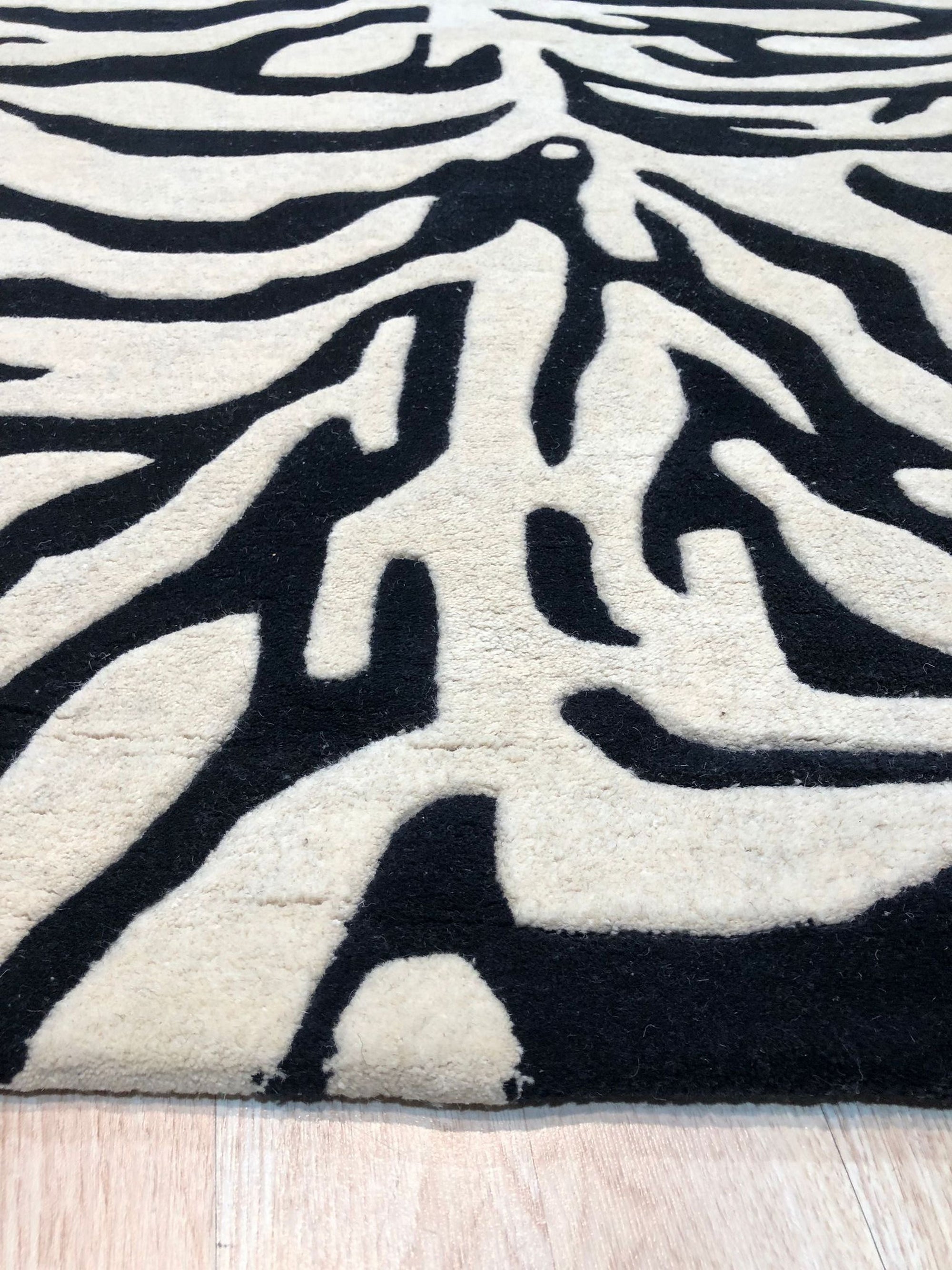 Cassandra Elegant Black Hand Tufted Wool Rug, hand-tufted for soft texture and showcasing intricate patterns in deep black tones, complements a modern living space.