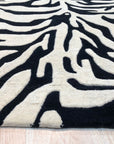 Cassandra Elegant Black Hand Tufted Wool Rug, hand-tufted for soft texture and showcasing intricate patterns in deep black tones, complements a modern living space.