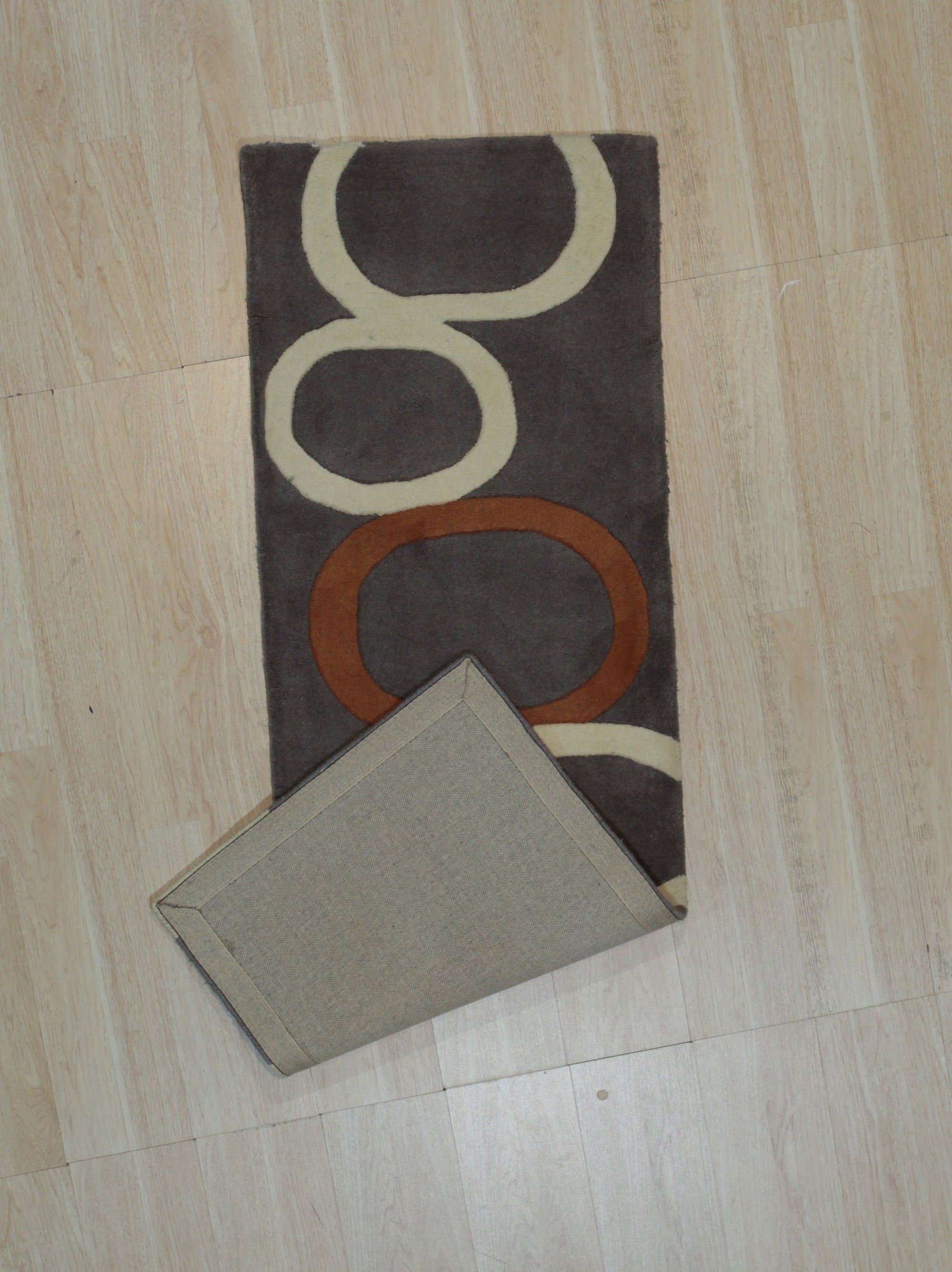 Celia Clara Gray Hand Tufted Wool Rug graces a light-filled living room, its soft gray tones complementing neutral furniture and adding subtle texture to the space.