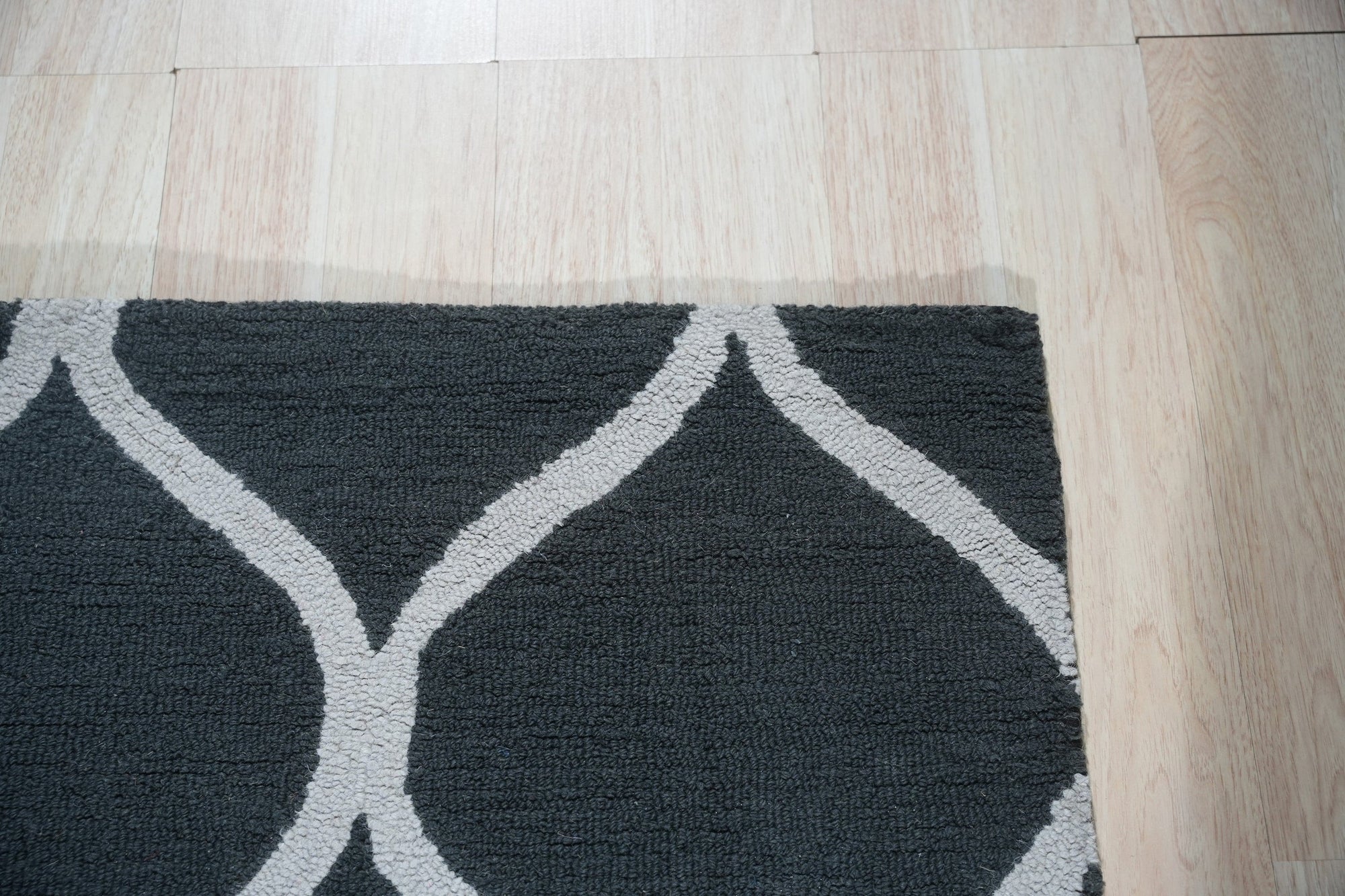 Beautiful Luna Black Hand Tufted Wool Rug, its deep black wool pile inviting touch and warmth, subtly textured and grounding the modern living room space.