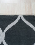 Beautiful Luna Black Hand Tufted Wool Rug, its deep black wool pile inviting touch and warmth, subtly textured and grounding the modern living room space.