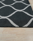 Beautiful Luna Black Hand Tufted Wool Rug, its plush texture and deep black hue grounding a contemporary living space, light subtly highlighting the hand-tufted construction.