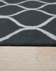 Beautiful Luna Black Hand Tufted Wool Rug, rich black wool lending depth and texture to a modern living room, its hand-tufted construction evident in the plush pile and subtle design variations underfoot.