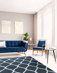 Beautiful Luna Black Hand Tufted Wool Rug, a deep charcoal wool rug with subtle, shimmering variations in tone, laid on a light hardwood floor, inviting warmth and texture to the space.