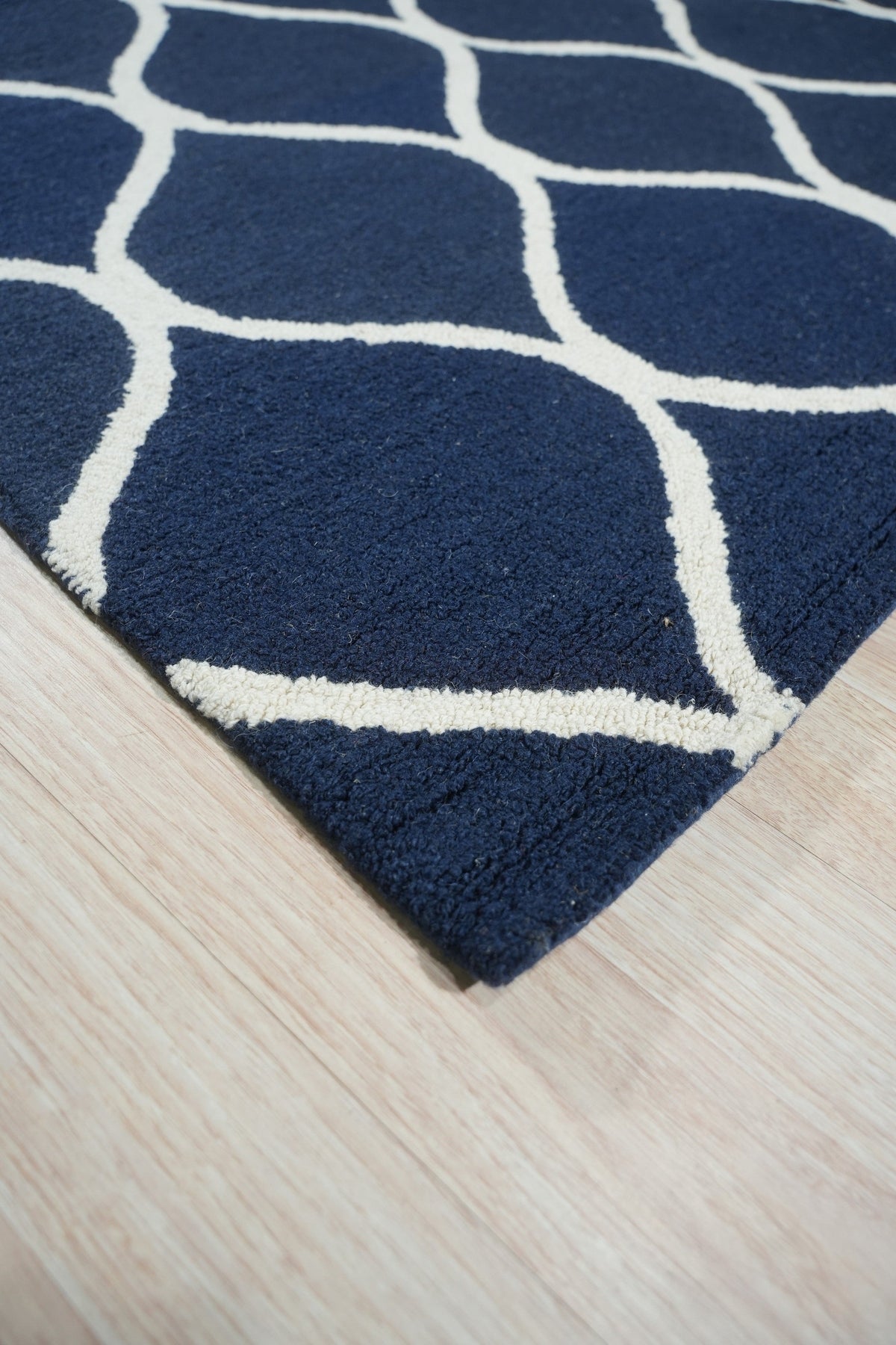 Jasmine Artisan Blue Hand Tufted Wool Rug, offering a textural landscape of deep blues and creamy whites in a modern geometric pattern, complements a light-filled living space with its soft wool pile and artisan-crafted feel.
