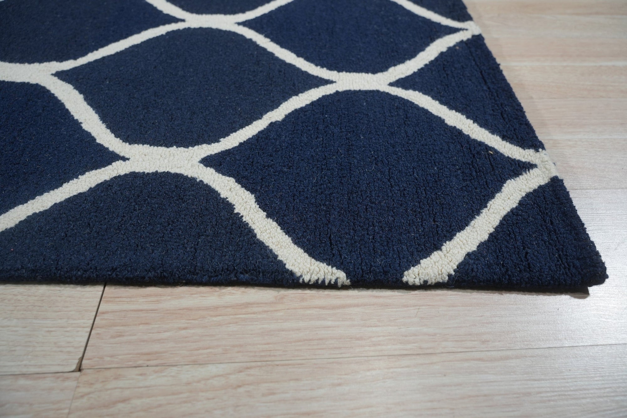 Jasmine Artisan Blue Hand Tufted Wool Rug displayed in a bright living room setting. Soft, blue hues blend across the hand-tufted wool pile, creating a calming and inviting space.