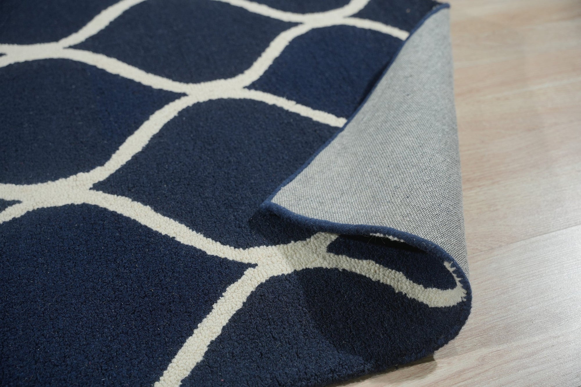 Jasmine Artisan Blue Hand Tufted Wool Rug, showcased in a bright living room setting. Hand-tufted wool construction creates plush texture. Muted blue hues and subtle patterns soften the space. Position 6.