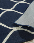 Jasmine Artisan Blue Hand Tufted Wool Rug, showcased in a bright living room setting. Hand-tufted wool construction creates plush texture. Muted blue hues and subtle patterns soften the space. Position 6.