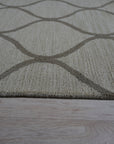 Zinnia Clara Light Gold Hand Tufted Wool Rug, its subtle gold hues radiating warmth within a softly lit space.