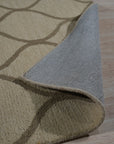 Zinnia Clara Light Gold Hand Tufted Wool Rug, its soft golden hues and plush wool texture grounding a warmly lit living room, accented by contemporary furniture.