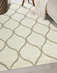 Zinnia Clara Light Gold Hand Tufted Wool Rug, its textured pile radiating warmth under soft light, complements a modern living room with neutral furniture.