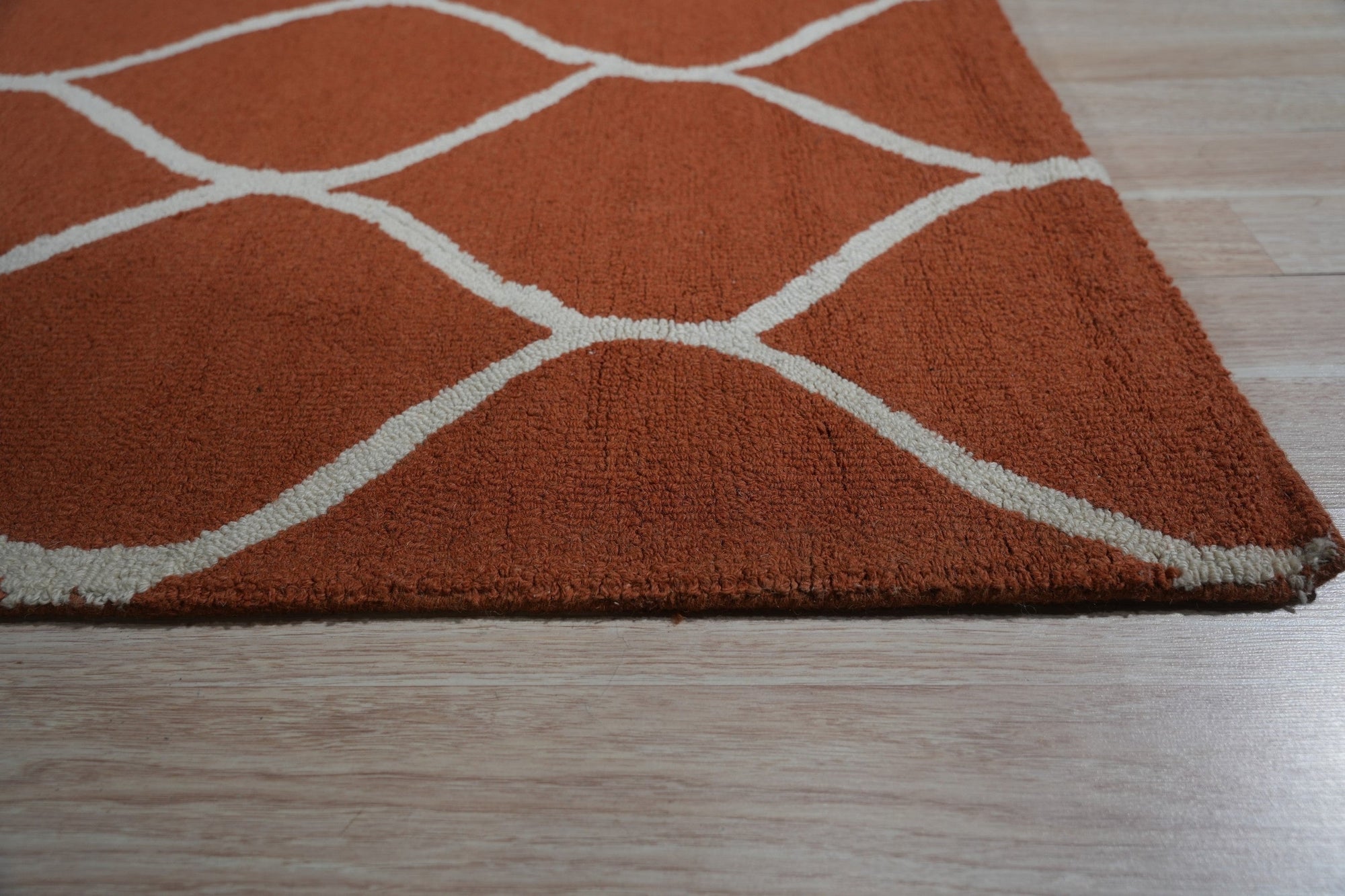 Maya Rustic Orange Hand Tufted Wool Rug, warm orange hues and textured wool create a rustic feel, seen as part of a room setting suggesting cozy, casual comfort.