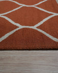 Maya Rustic Orange Hand Tufted Wool Rug, warm orange hues and textured wool create a rustic feel, seen as part of a room setting suggesting cozy, casual comfort.