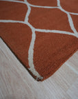 Maya Rustic Orange Hand Tufted Wool Rug, a vibrant blend of orange tones woven into a hand-tufted wool texture, lending warmth and rustic charm to a modern living space.