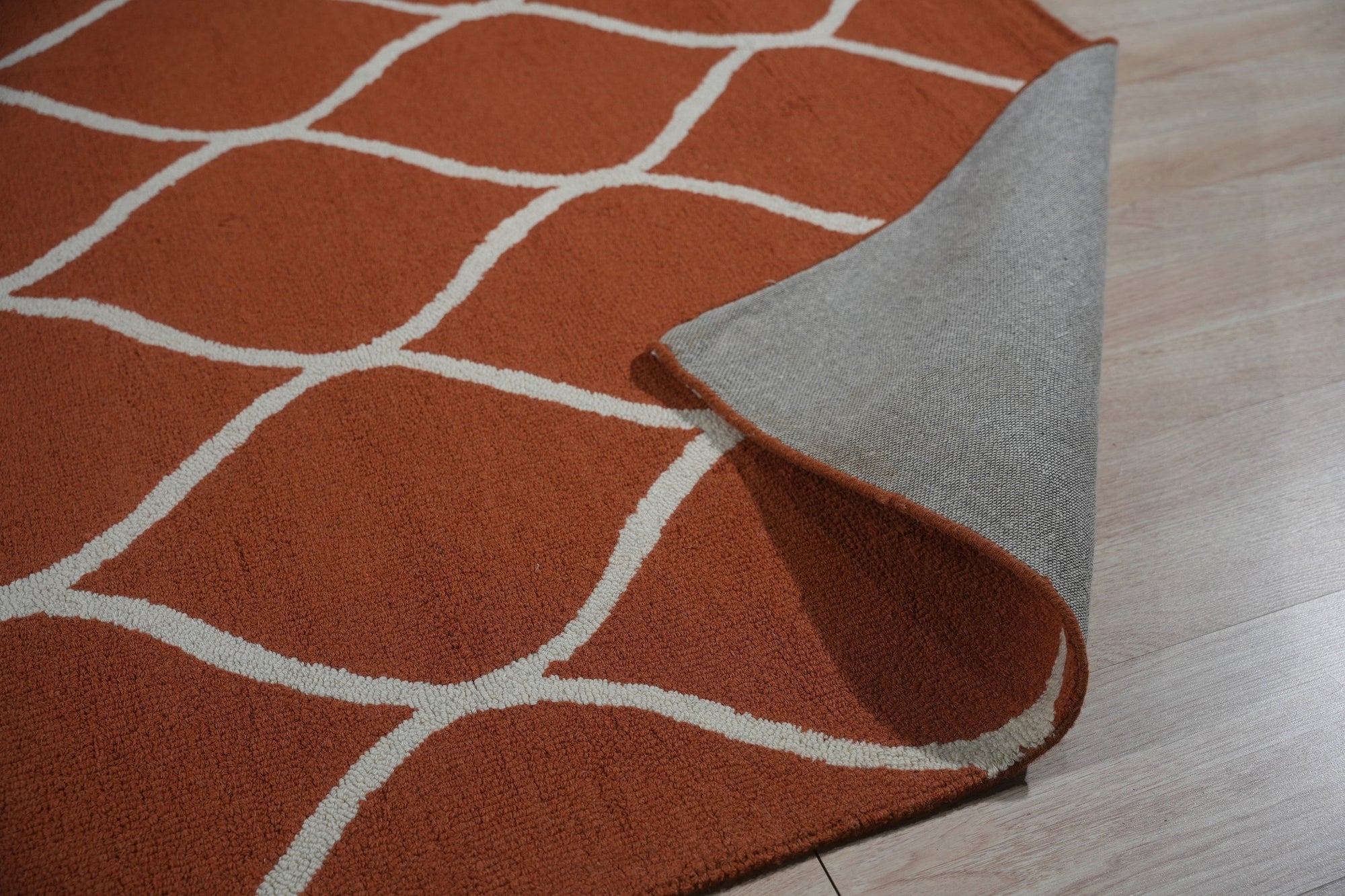 Maya Rustic Orange Hand Tufted Wool Rug, showcasing warm orange hues and textured design, lending rustic charm to a bright, airy living room setting.