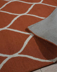 Maya Rustic Orange Hand Tufted Wool Rug, showcasing warm orange hues and textured design, lending rustic charm to a bright, airy living room setting.