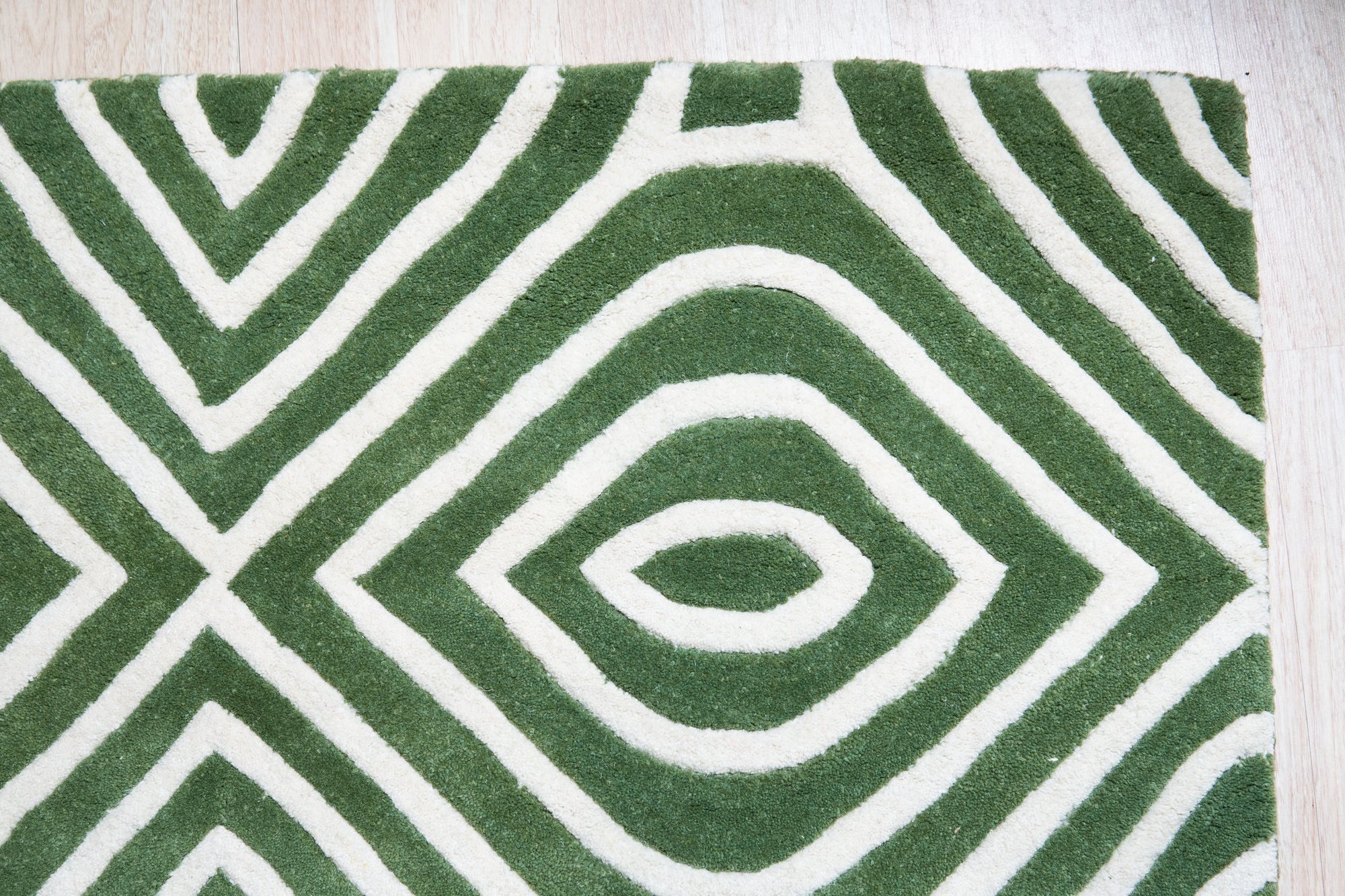 Radiant Amara Green Hand Tufted Wool Rug, its verdant hues and plush hand-tufted texture lending warmth and elegance to a modern living space with neutral furniture.